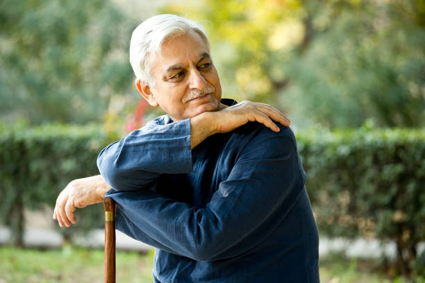 istock Senior man at park with walking cane 1213500397