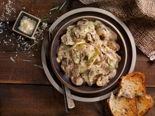cheese ravioli with sausage and mushrooms in a  rosemary cream sauce - portion cheese baguette bread imagens e fotografias de stock