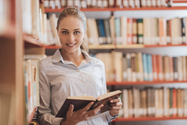 istock Woman searching books at the library 1213503244