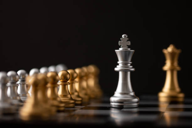istock Silver king and gold queen on chessboard 1213505184