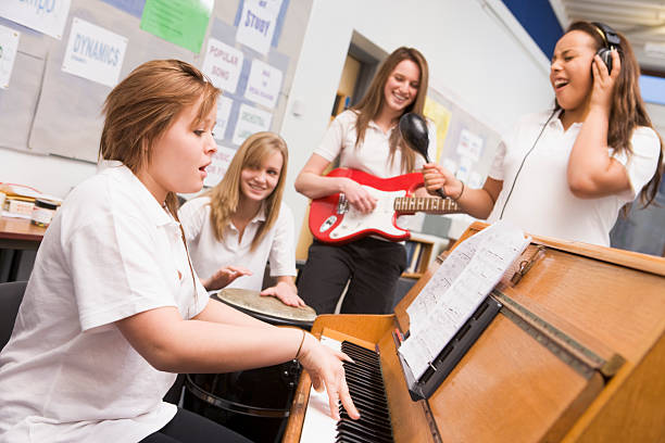 istock Schoolgirls playing musical instruments in music class 121350540