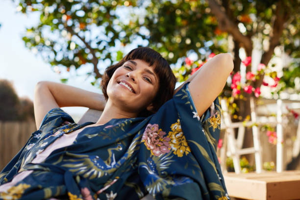 Smiling woman lying back in a deck chair on her patio