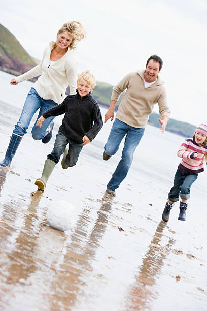 istock Family playing soccer at beach 121350622