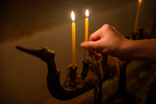 Man hand holding yellow candle