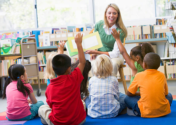 istock Kindergarten teacher reading to children 121350642