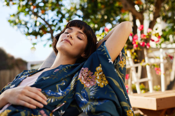 istock Young woman sleeping on a deck chair on a sunny afternoon 1213506428