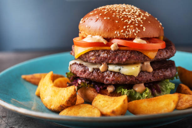 istock Burger on rustic wooden background served with potatoes. Burger kitchen background. Burger stock photos 1213506440