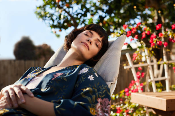 Young woman sleeping on a deck chair on her patio