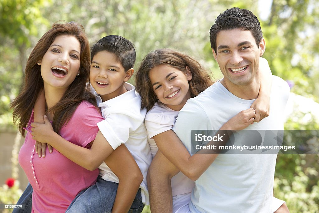 Família feliz de quatro pessoas em um parque - Foto de stock de Família royalty-free