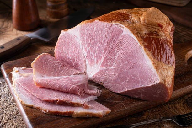 Naturally Smoked Ham A delicious naturally smoked ham on a rustic wood cutting board. smoked food stock pictures, royalty-free photos & images