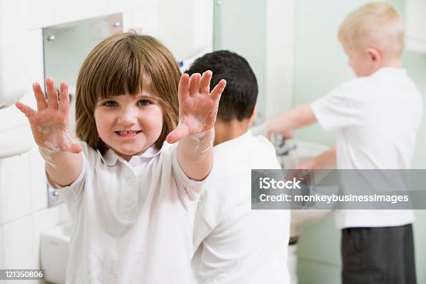 Chica Mostrando Su Soapy Manos En Una Escuela Primaria Baño Foto de stock y más banco de imágenes de Lavarse las manos