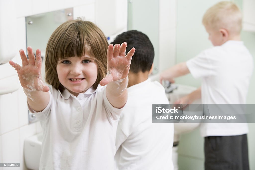 Ragazza con le mani con un sapone scuola primaria bagno - Foto stock royalty-free di Lavarsi le mani