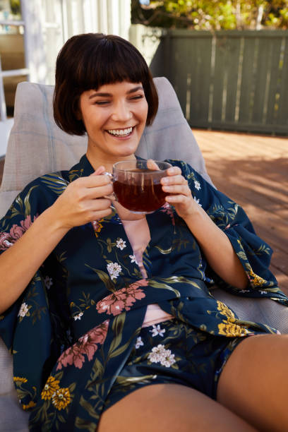 istock Laughing young woman drinking tea on her patio 1213508650