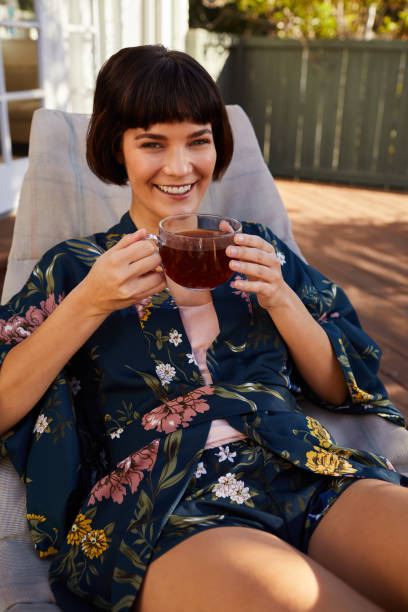 istock Smiling young woman drinking tea on her patio 1213508836