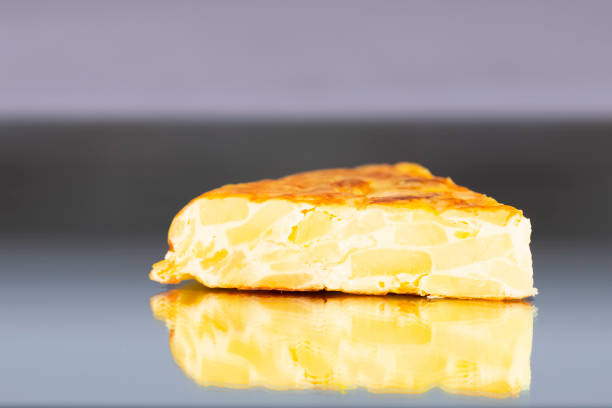 Close-up of a delicious slice of traditional spanish omelet on an out of focus background. Spanish and traditional food concept.