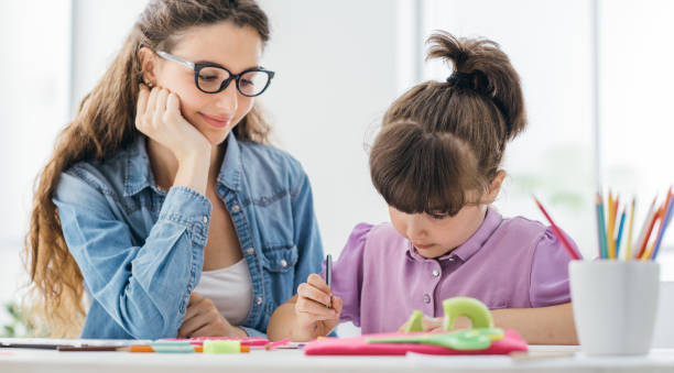istock Teacher and girl drawing at school 1213510010