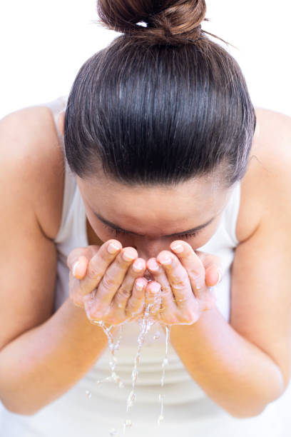 istock Young woman washing her face 1213513227
