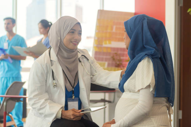 Muslim Doctor talking to her pregnant patient Mualim pregnant woman wearing hijab sitting and listening to the gynecologist for her medical exam report in the hospital indonesian ethnicity stock pictures, royalty-free photos & images