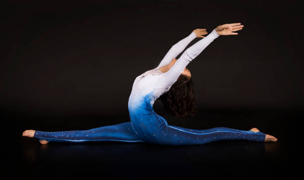 istock Girl acrobat, gymnastics, a young athlete in a blue and white suit , practicing acrobatics. 1213514585