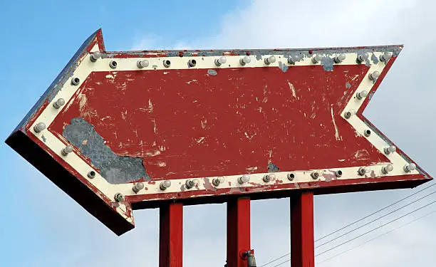 Photo of Vintage Red Arrow Sign with Sky Background