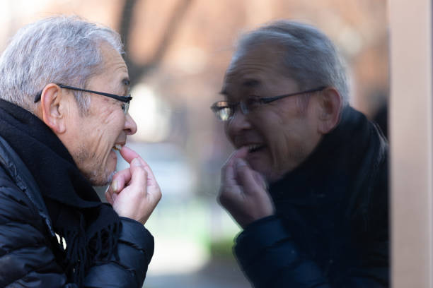 istock Senior man looking at himself in window reflection 1213519360