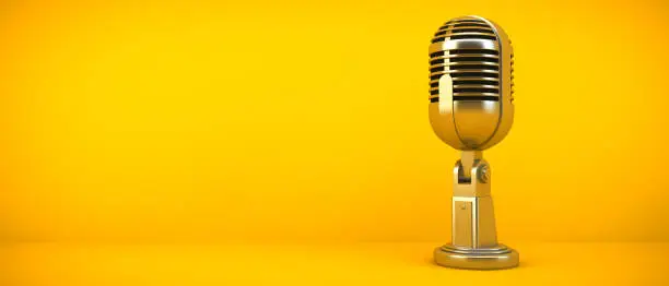 Photo of gold microphone on yellow background