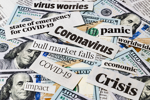 Coronavirus, covid-19 news headlines on United States of America 100 dollar bills. Concept of financial impact, stock market decline and crash due to worldwide pandemic
