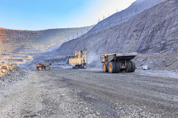 istock Excavator and two trucks in the iron ore quarry 1213523579