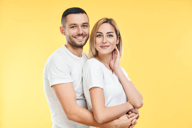 istock Young happy couple hugging over yellow background 1213524633