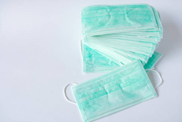green color medical mask for protection against flu and other diseases. surgical protective mask. medical respiratory bandage face on isolate white background. prevention of the spread of virus - flu virus cold and flu swine flu epidemic imagens e fotografias de stock