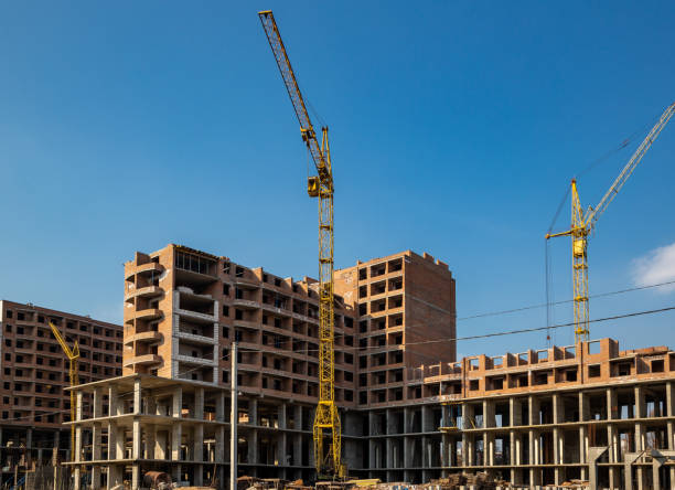 istock Work in progress on a new apartment block. Tall building under construction with cranes. Construction Site of New Building 1213525769