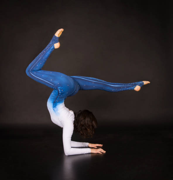 istock Girl acrobat, gymnastics, a young athlete in a blue and white suit , practicing acrobatics. 1213525824