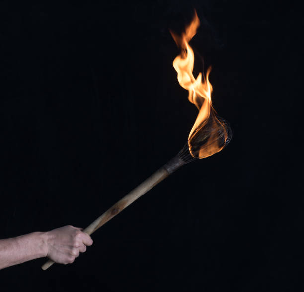 istock wooden burning torch on a black background 1213527471
