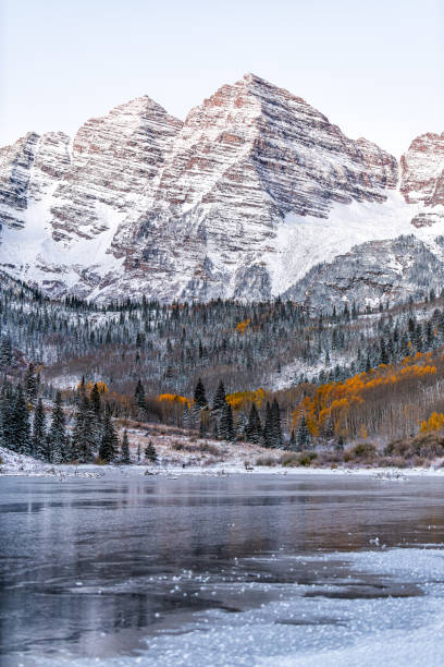 Maroon Bells morning sunrise peak vertical view in Aspen, Colorado rocky mountain and autumn yellow foliage and winter snow Maroon Bells morning sunrise peak vertical view in Aspen, Colorado rocky mountain and autumn yellow foliage and winter snow ice lakes colorado stock pictures, royalty-free photos & images