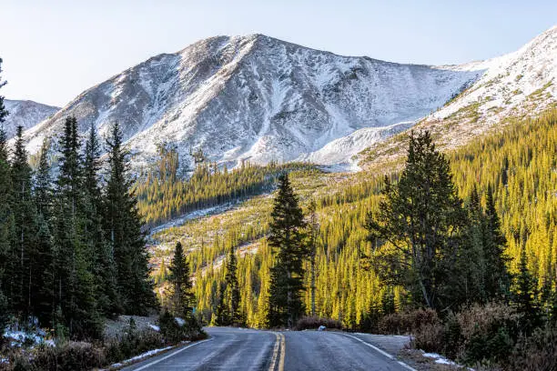 Photo of Independence Pass snow rocky mountain view and paved road scenic byway in morning sunrise near Aspen, Colorado in green autumn winter
