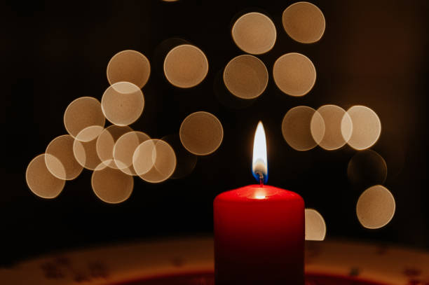 istock Red candle burning with defocussed light behind, bokeh background 1213527734