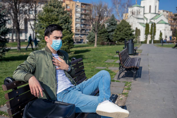 istock Tired man with a mask on his face sits on a bench. 1213528727