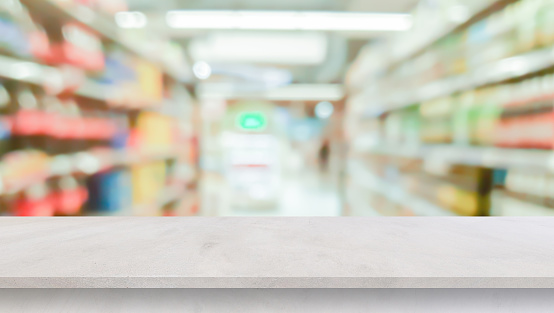 desdibujar el fondo de la tienda de conveniencia del supermercado local con la encimera de cemento gris de perspectiva para mostrar el producto o anuncios banner y promover el marketing en el concepto de pantalla photo
