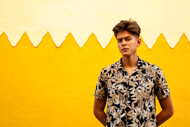 istock Young model with bad boy face with yellow wall background. 1213529265