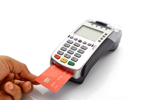 istock Hand swipe red credit through payment terminal on white background 1213529356