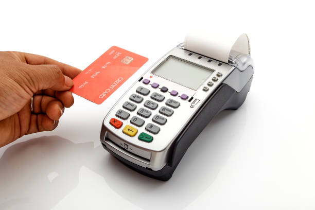 istock Hand swipe red credit through payment terminal on white background 1213529357