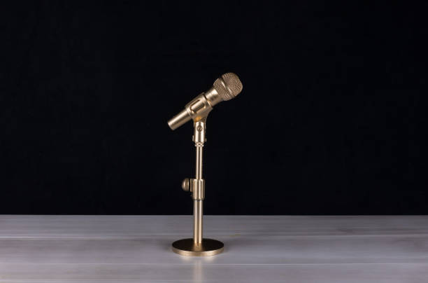 istock golden microphone isolated on black background 1213530796
