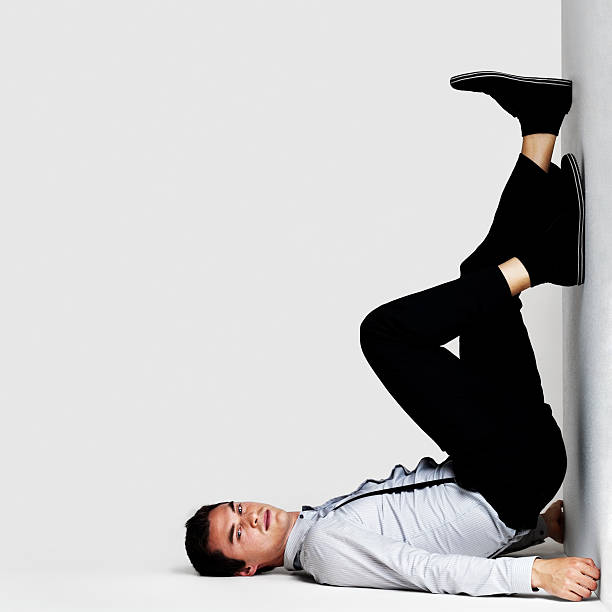istock Man lying on floor with legs up against a wall 121353204