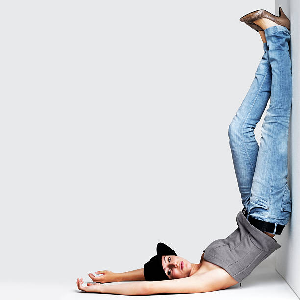 istock Upside down - Young woman with legs up against wall 121353238