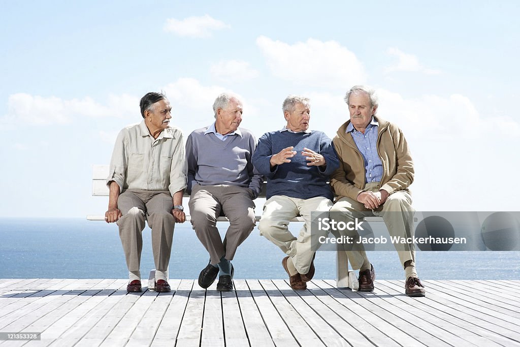 Macho maduro grupo de amigos sentados juntos no banco - Royalty-free Discussão Foto de stock