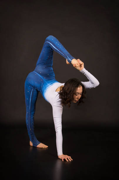 istock Girl acrobat, gymnastics, a young athlete in a blue and white suit , practicing acrobatics. 1213533581
