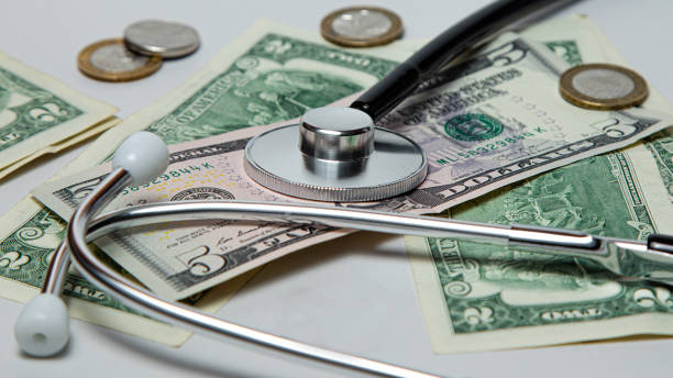 istock financial crisis, on the table dollars, calculator and stethoscope 1213533621
