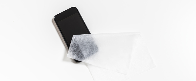 Disinfecting cellphone screen with a alcohol antiseptic cloth during the virus outbreak