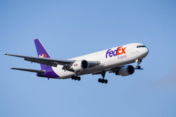 FedEx Express aircraft preparing for landing March 13, 2020 San Jose / CA / USA - FedEx Express aircraft approaching San Jose International Airport; FedEx Express is an American cargo airline, subsidiary of FedEx Corporation landing touching down stock pictures, royalty-free photos & images