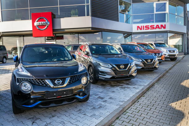 Nissan motor company car standing in front of dealership building stock photo